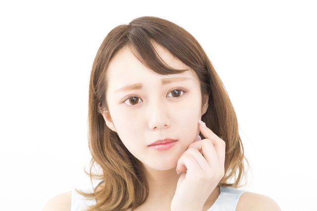 鏡の前で丁寧にスキンケアを行い、拭き取り化粧水や引き締め美容液でお手入れをすることで、毛穴の目立たないなめらかな肌印象を目指している女性の様子｜アーバンコスメ