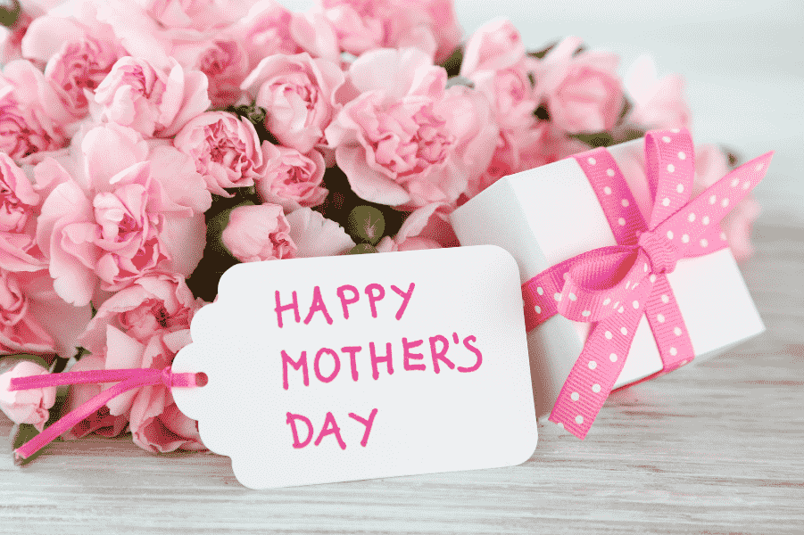 「HAPPY MOTHER'S DAY」のメッセージカードとともに、ピンクのカーネーションとリボンをかけたギフトボックスを添えて、お母様への感謝を届ける準備を整えた様子｜アーバンコスメ