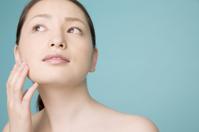 「引き算」と「足し算」の正しい毛穴ケアで、内側から密度が高まったすこやかな肌の質感を確かめながら、自信に満ちた晴れやかな表情を浮かべている女性の様子｜アーバンコスメ
